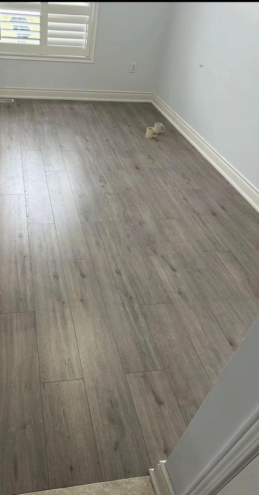 New grey vinyl plank floor in a Brampton bedroom with clean white baseboards