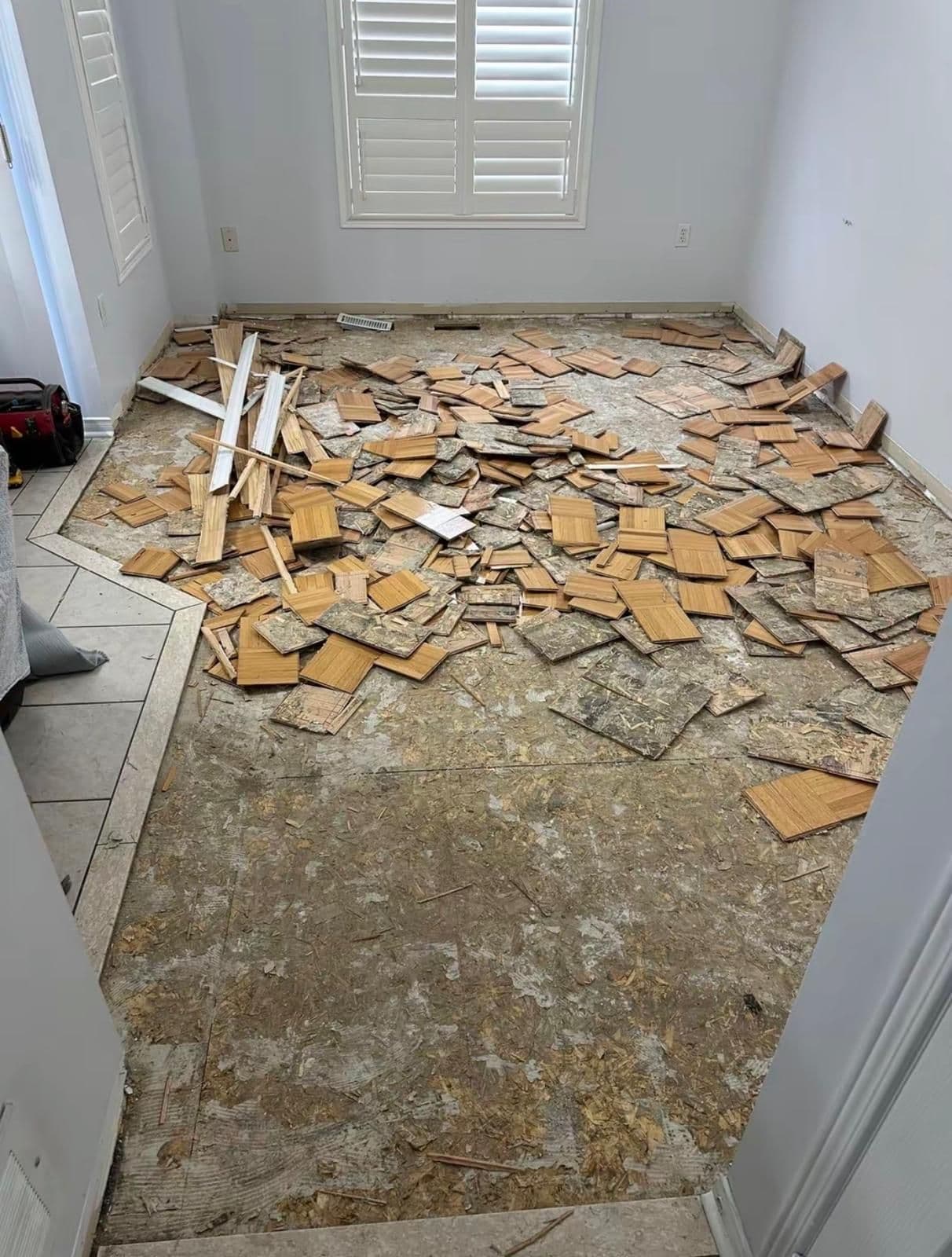 Old parquet flooring torn up during a bedroom floor replacement in Brampton